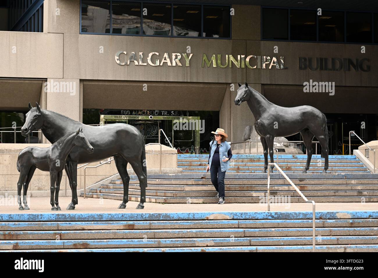 Calgary, Alberta, Canada - 5 juillet 2026 : Une femme près de l'entrée du Calgary Municipal Building. Banque D'Images
