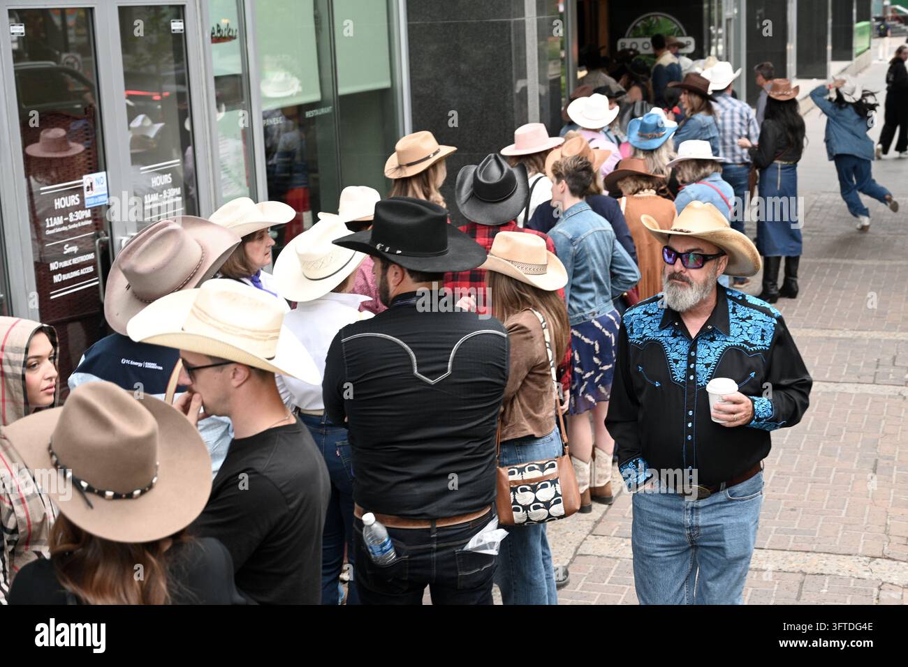 Calgary, Alberta, Canada – 5 juillet 2026 : Des personnes portant des chapeaux de cowboy dans une rue de Calgary lors du Calgary Stampede. Banque D'Images