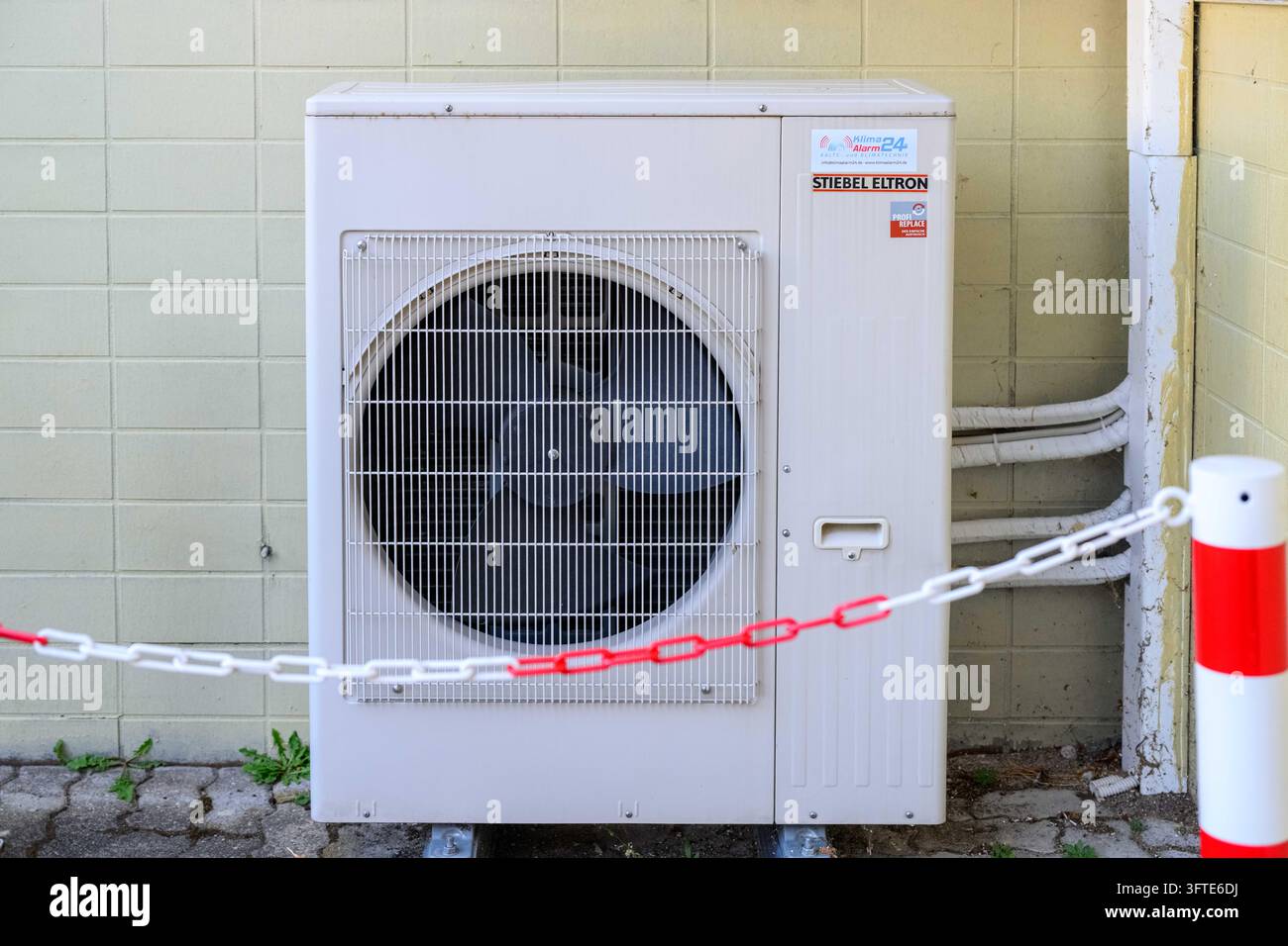 Unité extérieure d'une pompe à chaleur air-eau Stiebel Eltron derrière une chaîne de barrière. Image symbolique pour le remplacement du chauffage, la loi sur l'énergie des bâtiments et ene Banque D'Images