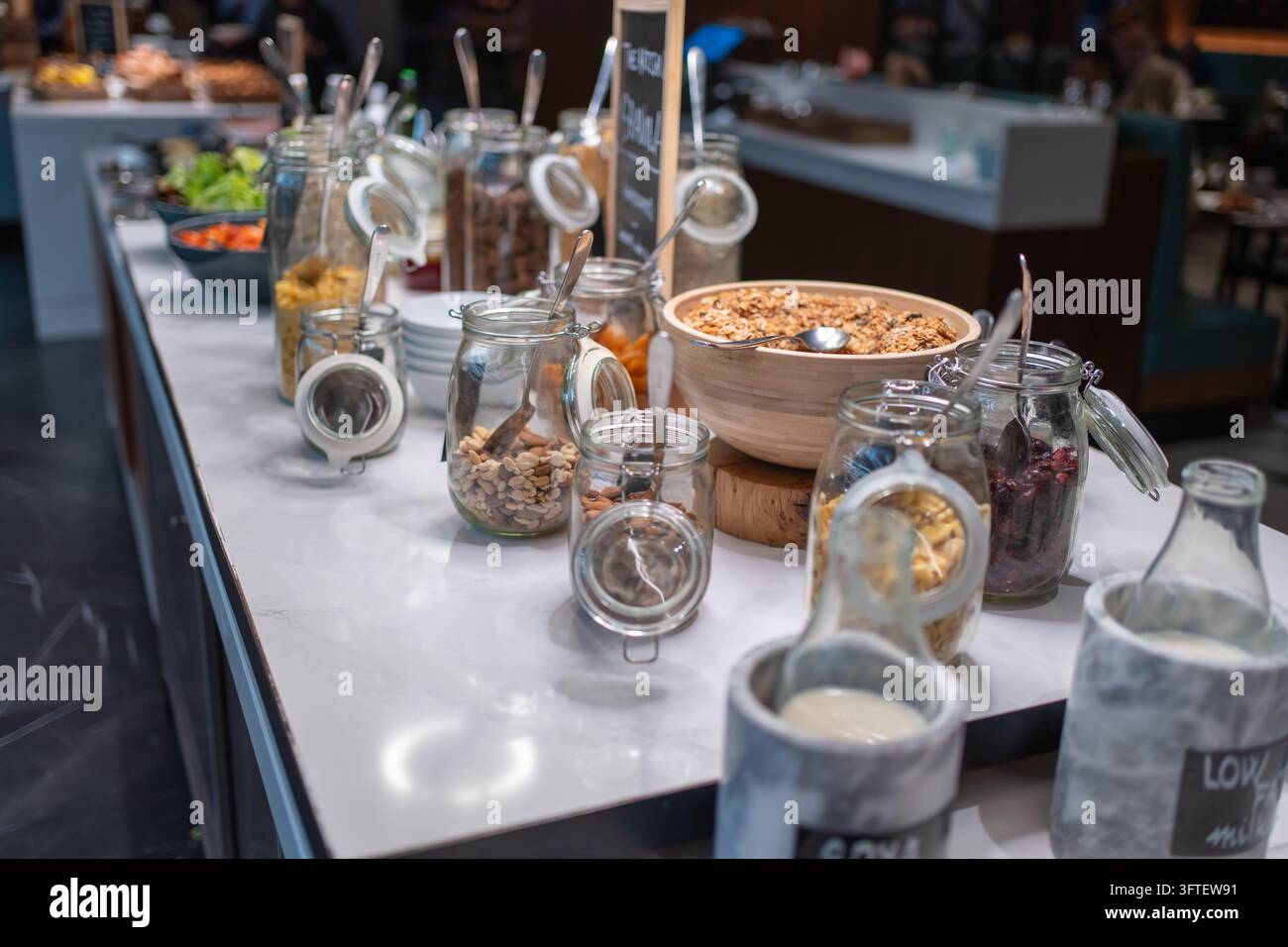Muesli, noix, fruits secs, céréales et lait sont disposés sur un buffet de petit-déjeuner à l'hôtel. Les invités peuvent choisir les ingrédients et créer leur propre petit-déjeuner Banque D'Images