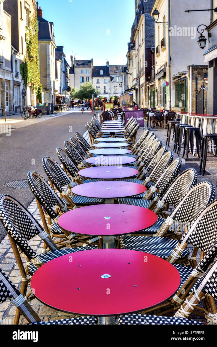 Rangee de tables rondes de café à dessus rouges et chaises devant un bistro / restaurant sur la Rue de Châteauneuf - Tours, Indre-et-Loire (37), France. Banque D'Images