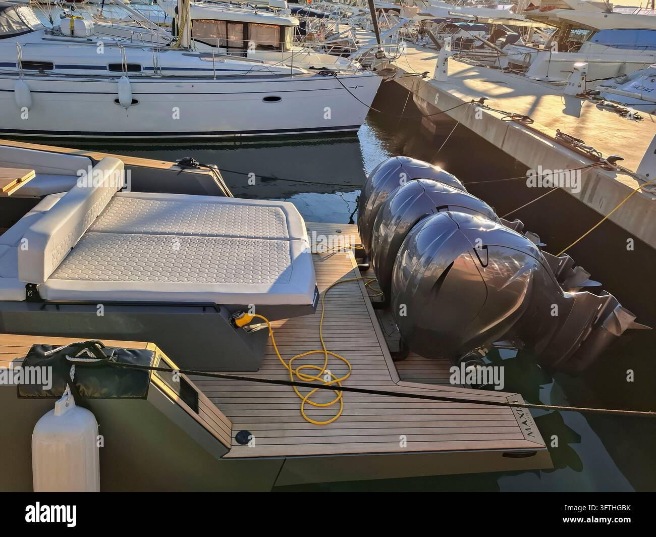 Perspective en hauteur du pont arrière et de la plateforme de baignade en teck d'un yacht à moteur de luxe moderne, doté de trois moteurs hors-bord puissants, d'un système intégré Banque D'Images