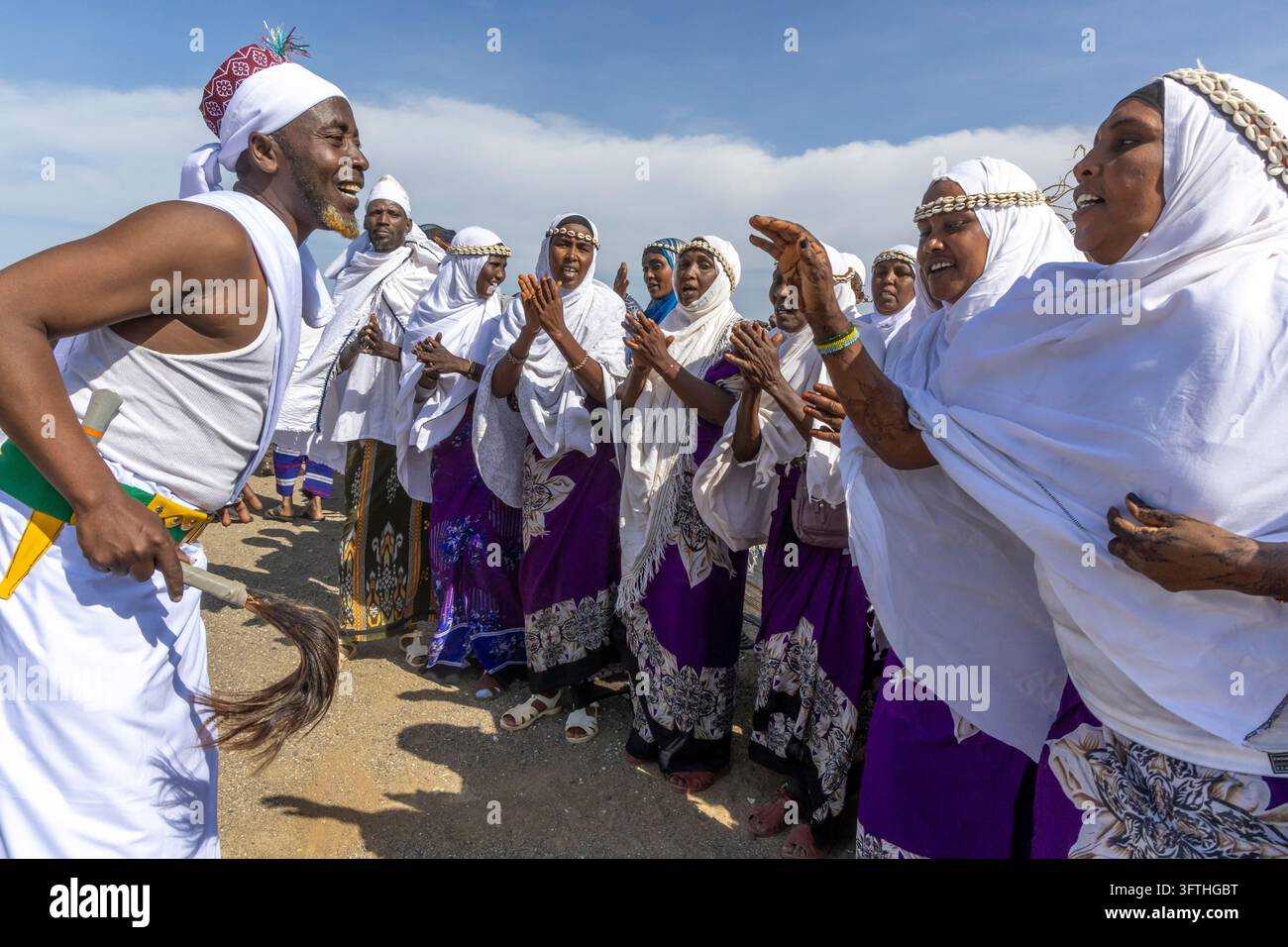 Homme de la tribu Borana en robes blanches dansant avec un fouet en crin au Festival culturel du lac Turkana, comté de Marsabit, Loiyangalani, Kenya Banque D'Images