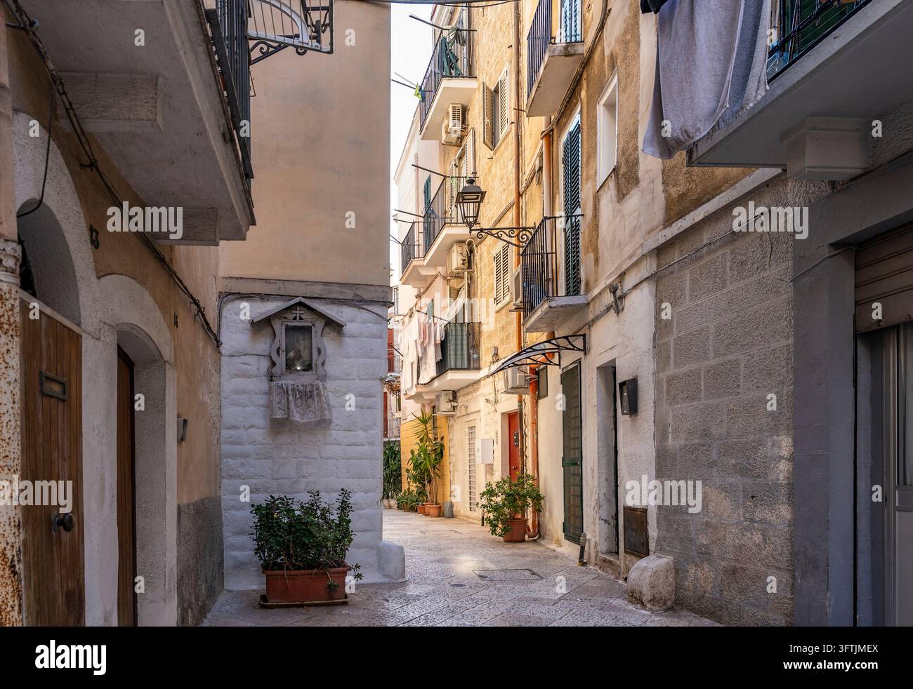 Allée pittoresque avec un petit sanctuaire religieux intégré dans un mur historique à Bari Vecchia, Bari, Pouilles, Italie Banque D'Images