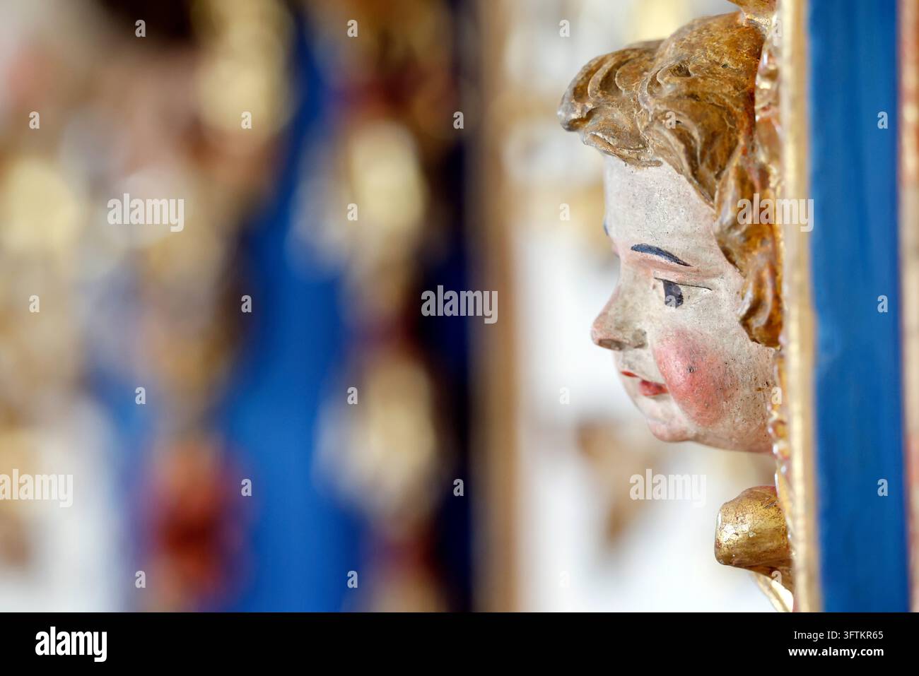 La chapelle baroque de La Gruvaz. Détail en gros plan du visage sculpté et peint d'un chérubin ornant un cadre doré, sur un fond. Saint G Banque D'Images