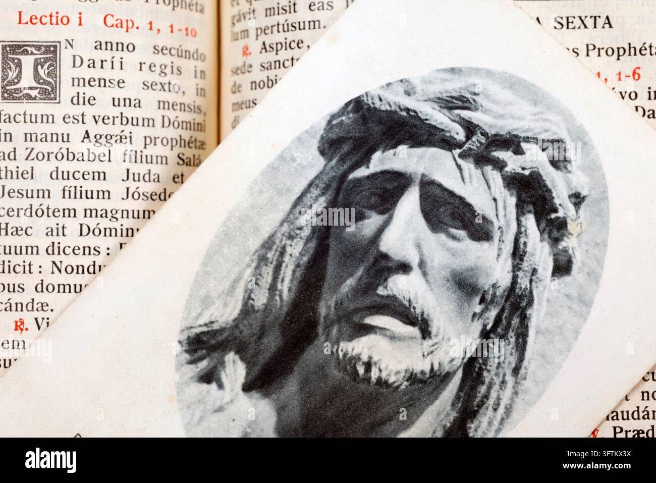Une image dévotionnelle imprimée représentant le visage de Jésus-Christ repose sur les pages ouvertes d'un missel liturgique écrit en latin. Banque D'Images