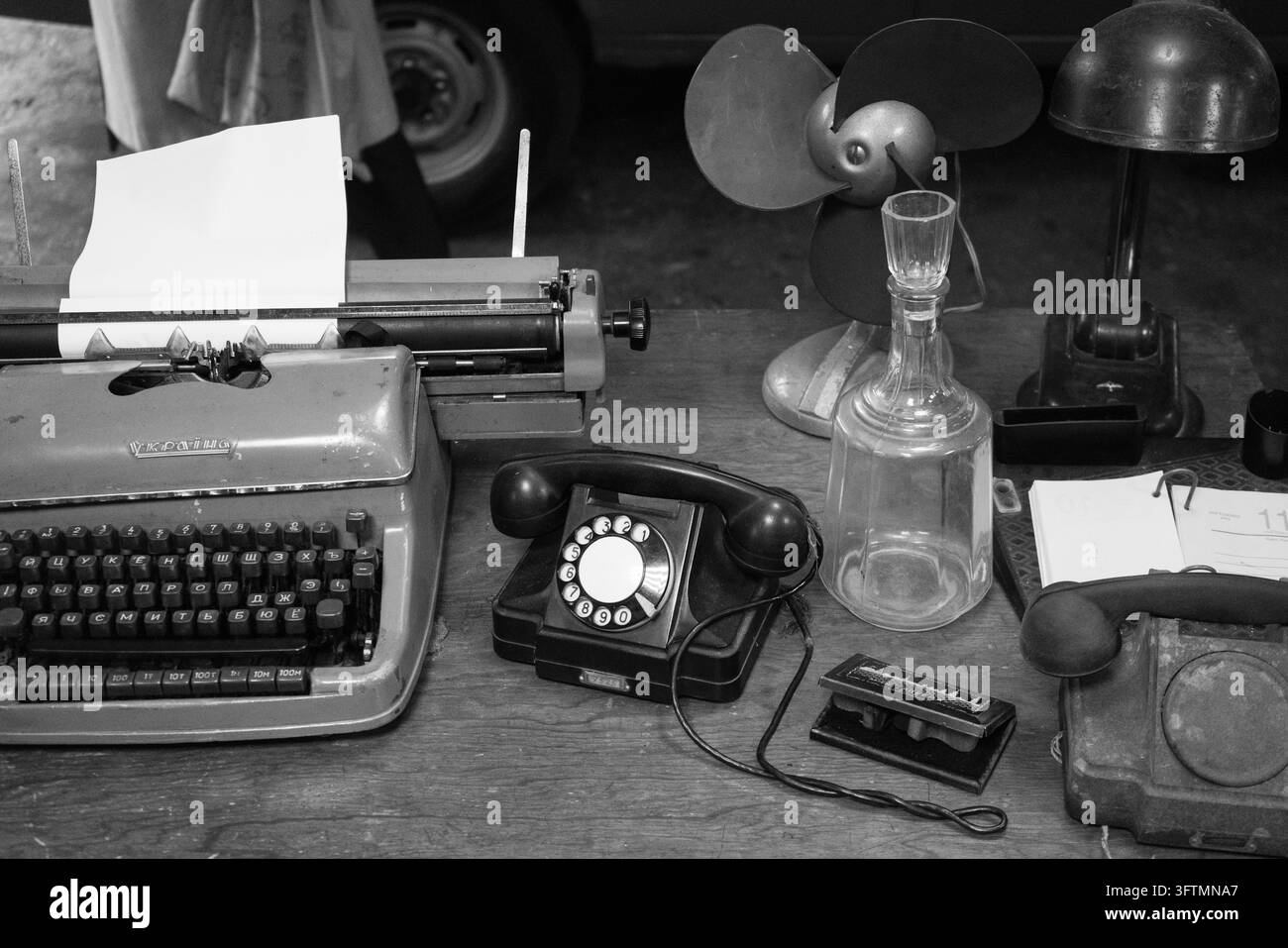 Machine à écrire vintage et téléphones à cadran sur un bureau en bois rustique avec carafe en verre Banque D'Images