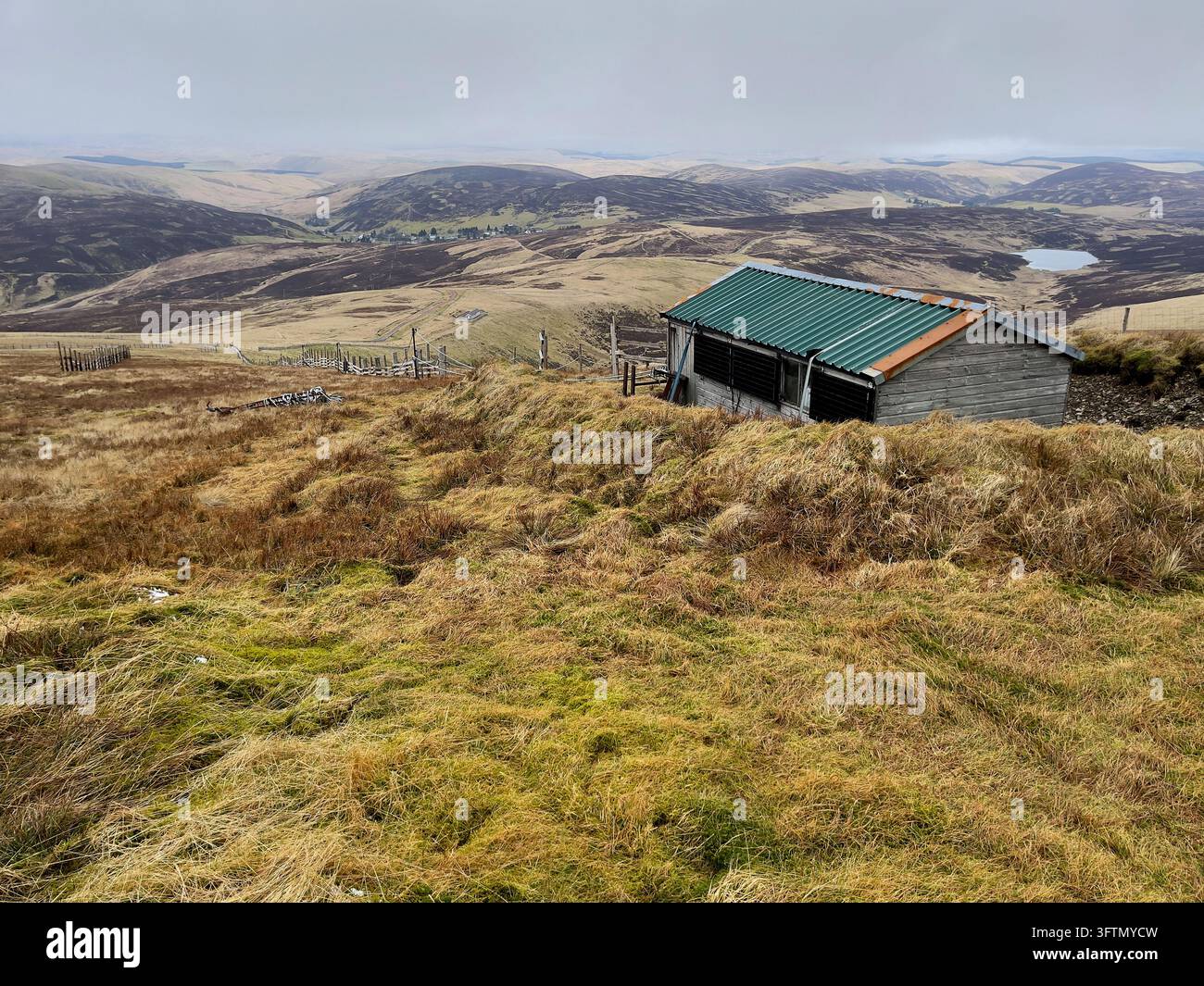 Téléski du Lowther Hills Ski Club avec clôture à neige et hangar moteur ainsi que les collines environnantes en mars. Banque D'Images