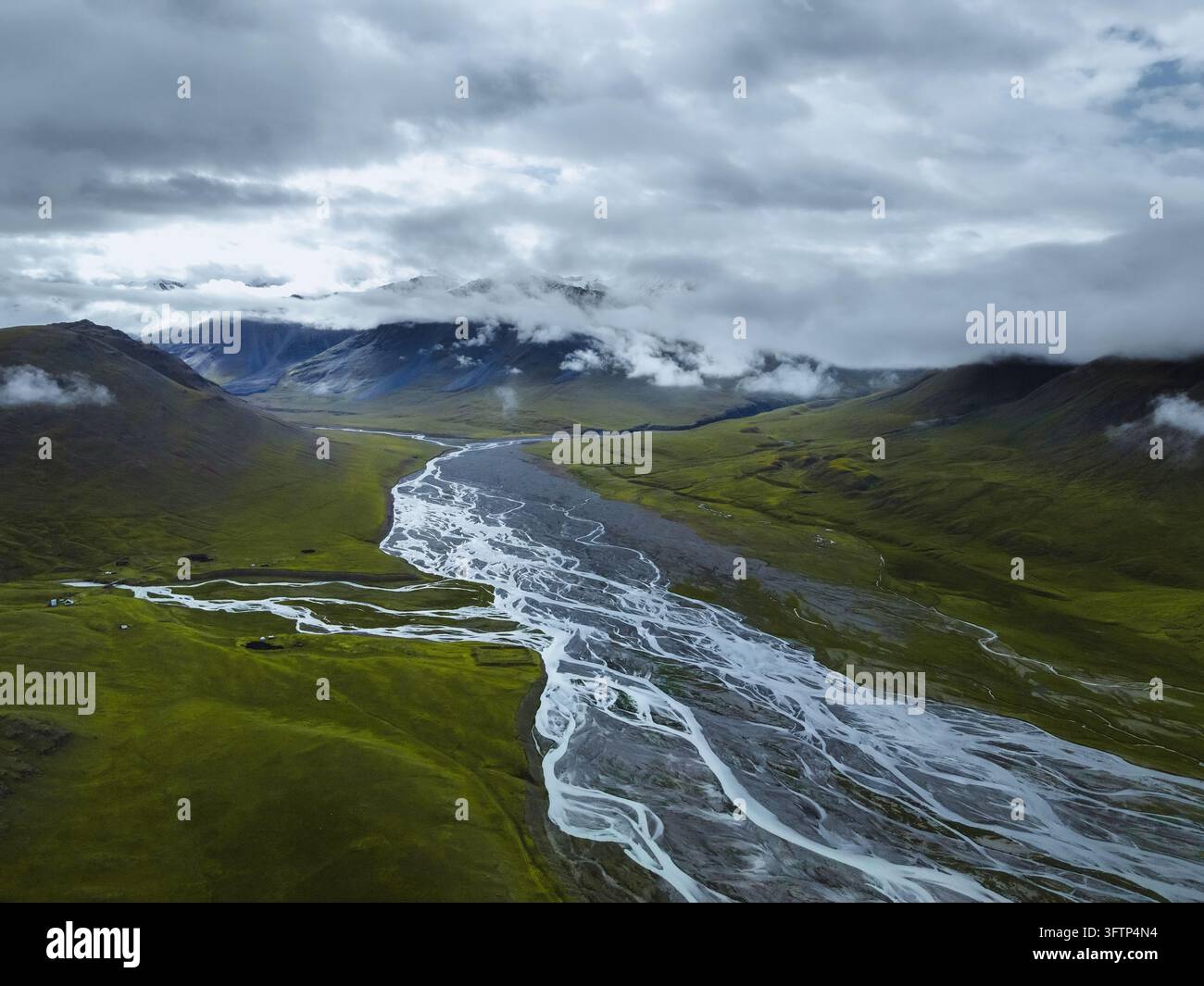 Vue aérienne panoramique de bras de rivière s'étendant à travers le large fond de vallée sous des nuages bas Banque D'Images