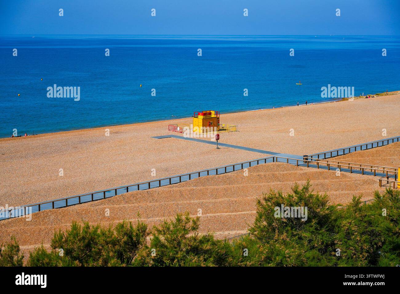 Poste de sauveteur jaune vif et rouge situé sur le rivage de galets de Brighton Beach à Brighton, en Angleterre, le long de la côte de la Manche Banque D'Images