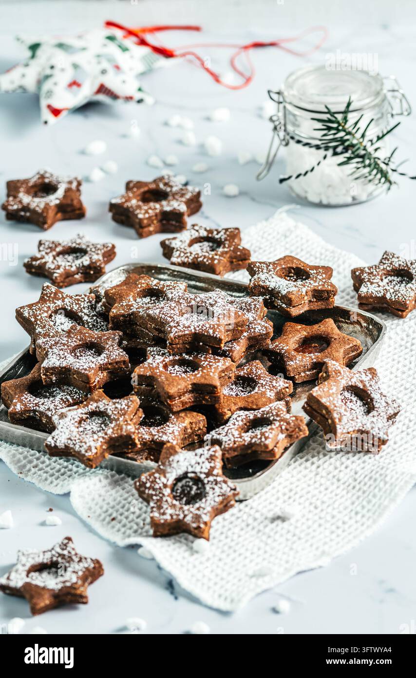 Biscuits de Noël Linz traditionnels remplis de confiture de coing sur fond blanc. Décorer avec des branches de sapin. Banque D'Images