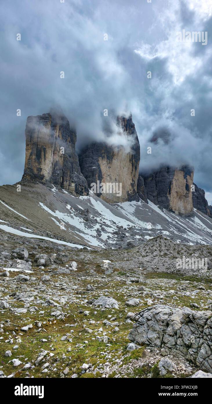 Vue dramatique des trois pics emblématiques des Tre Cime di Lavaredo dans les Dolomites italiennes, par une journée d'été nuageuse Banque D'Images