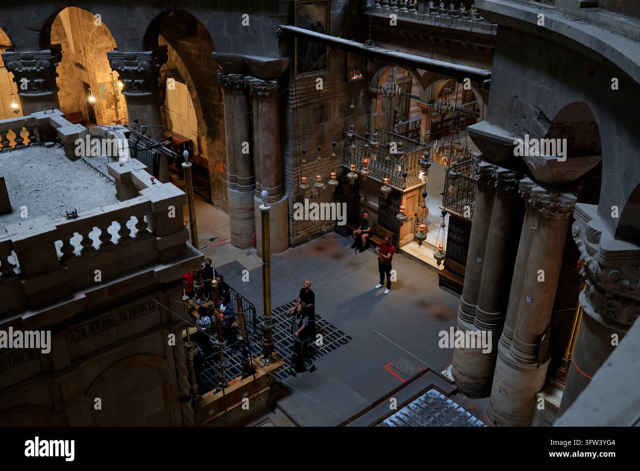 Jérusalem - 17 octobre 2026 : Des visiteurs se tiennent à côté de l'Édicule dans la rotonde de l'Église du Saint-Sépulcre, vus depuis une galerie supérieure. Banque D'Images