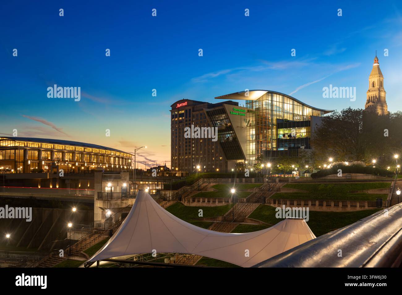 Hartford, Connecticut, États-Unis : Vue nocturne du centre-ville avec le Connecticut Science Center illuminé et la Travelers Tower. Banque D'Images