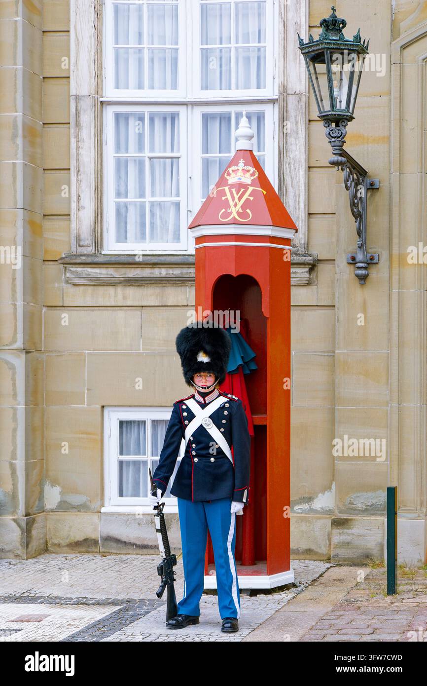 Une garde royale en bonnet d’ours debout en sentinelle à côté d’un kiosque rouge au palais d’Amalienborg, Copenhague, Danemark Banque D'Images