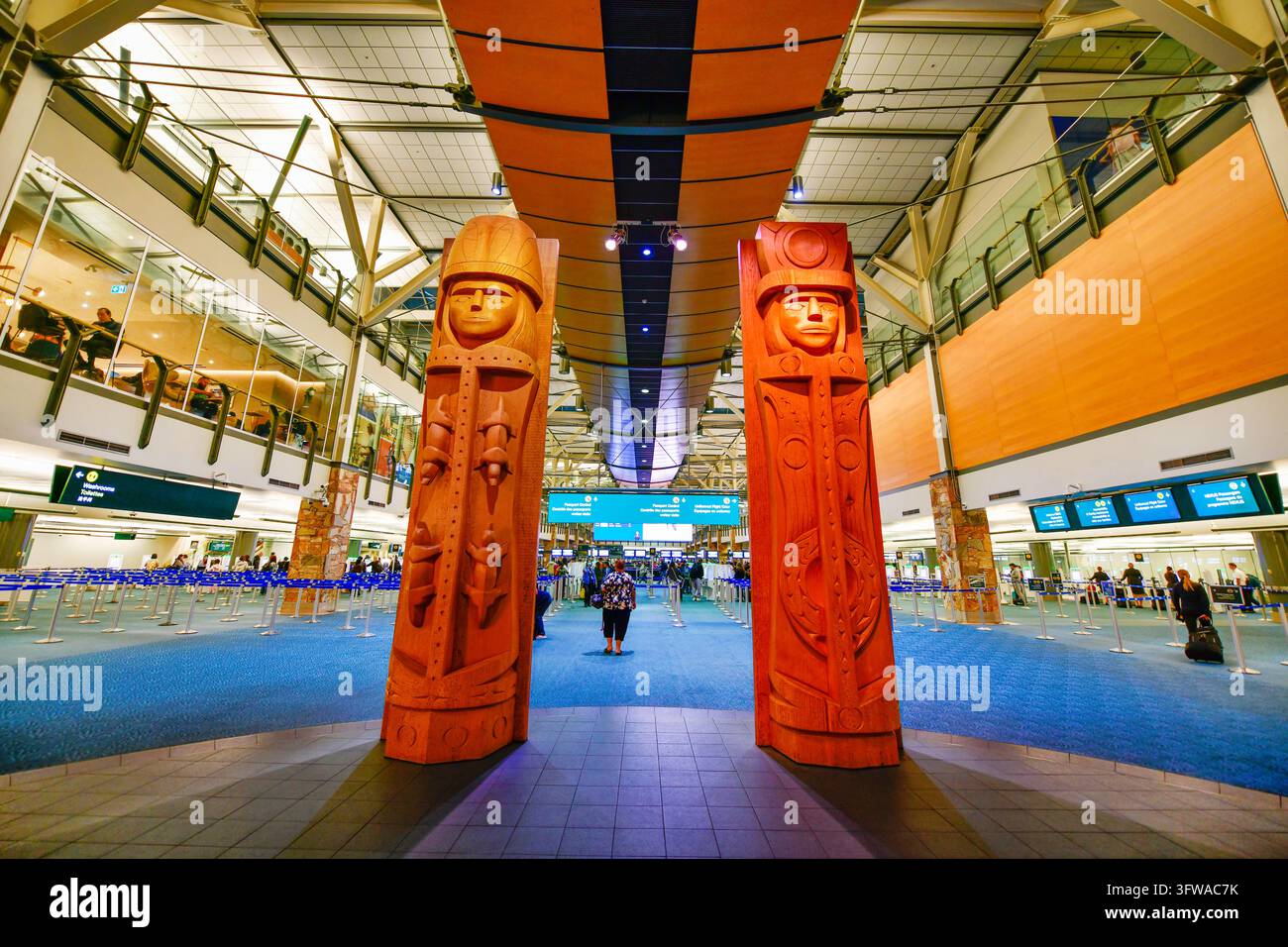 VANCOUVER, CANADA - 28 SEPT. 2026 : À l'intérieur de l'aéroport international de Vancouver (YVR) avec de grands poteaux totémiques autochtones en guise de bienvenue Banque D'Images