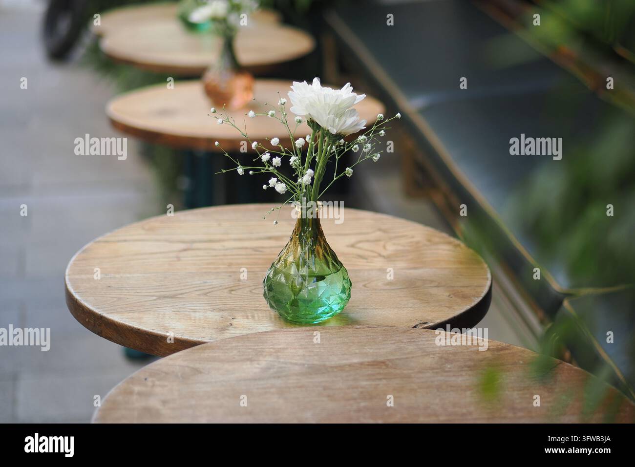 Fleurs blanches dans un vase vert sur une table de café pendant la journée Banque D'Images