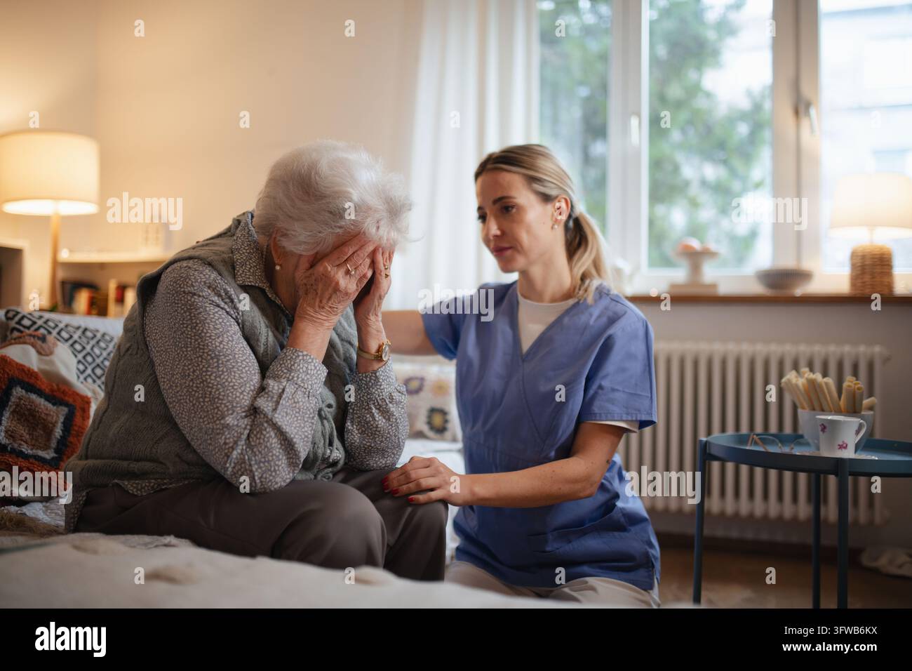 Infirmière embrassant le patient âgé, soutien en santé mentale et conseil en deuil à la femme âgée. Banque D'Images