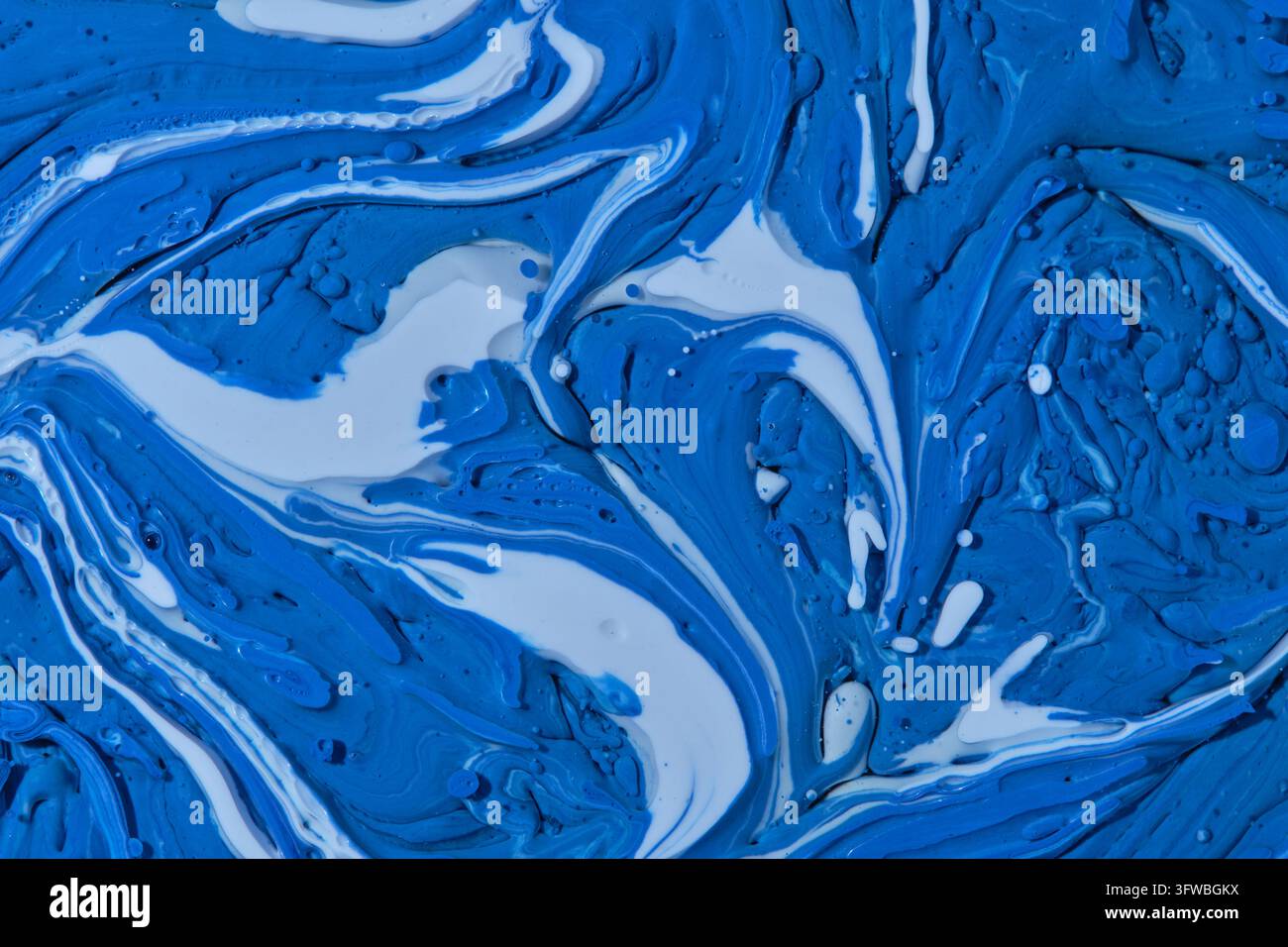 Motif en spirale abstrait de peinture fluide bleu vif et blanc créant un contraste artistique dynamique Banque D'Images