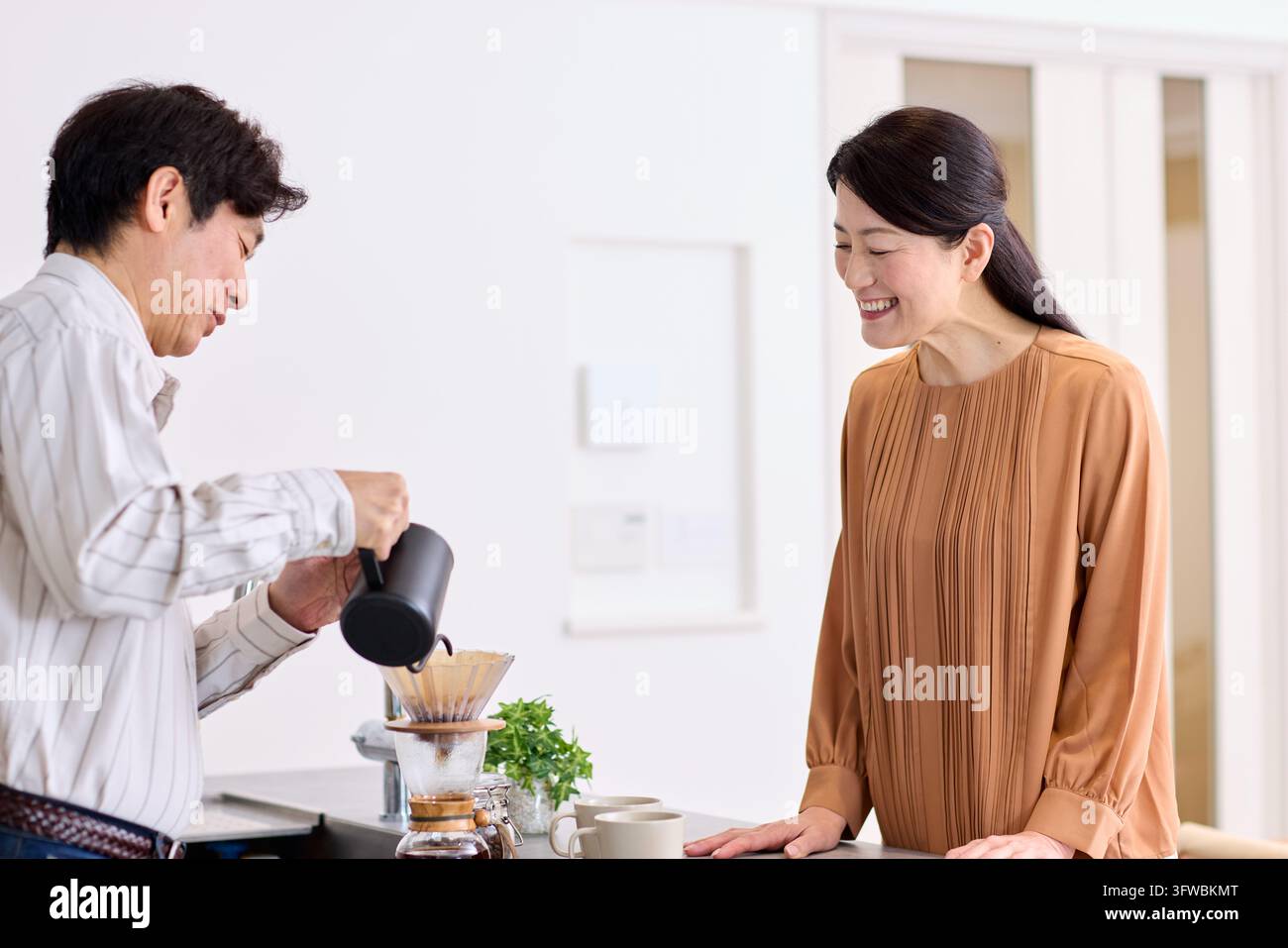 Couple japonais profitant d'un moment de paix avec une tasse de café fraîchement préparée Banque D'Images