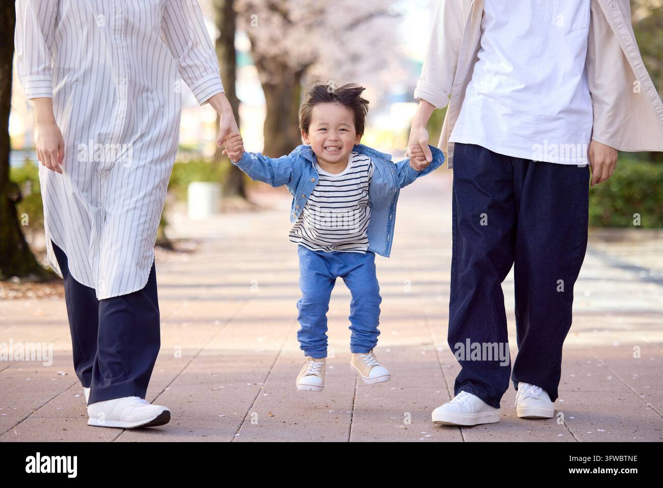 Parent et enfant japonais marchant main dans la main avec le sourire aux lèvres Banque D'Images