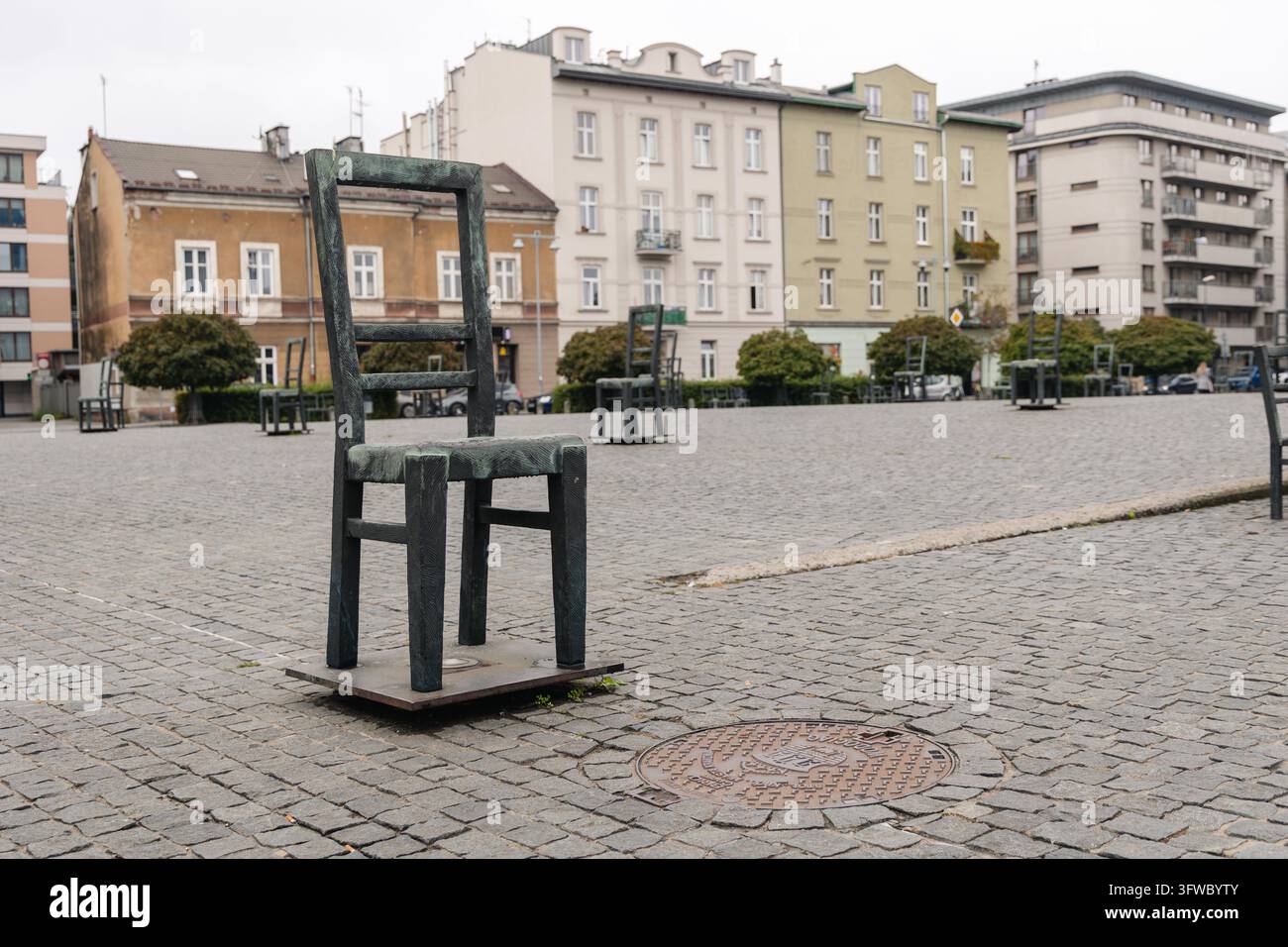 Place des Héros du Ghetto présentant le mémorial unique de 33 grandes chaises en bronze, rendant hommage aux victimes de la liquidation du ghetto de Cracovie Banque D'Images
