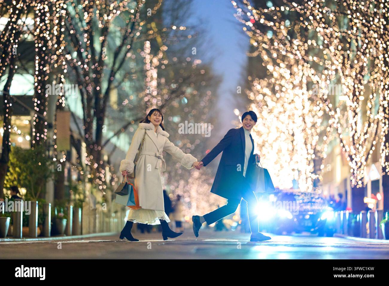 Couple japonais traversant un passage piéton avec le sourire Banque D'Images