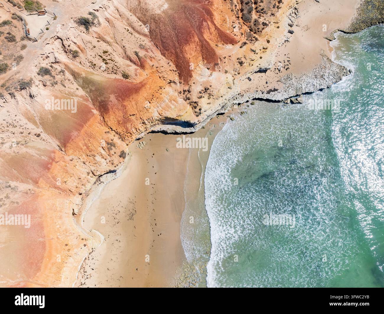 Vue aérienne des vagues roulant dans une petite baie en contrebas de falaises abruptes à Port Noarlunga à Adélaïde, en Australie du Sud. Banque D'Images