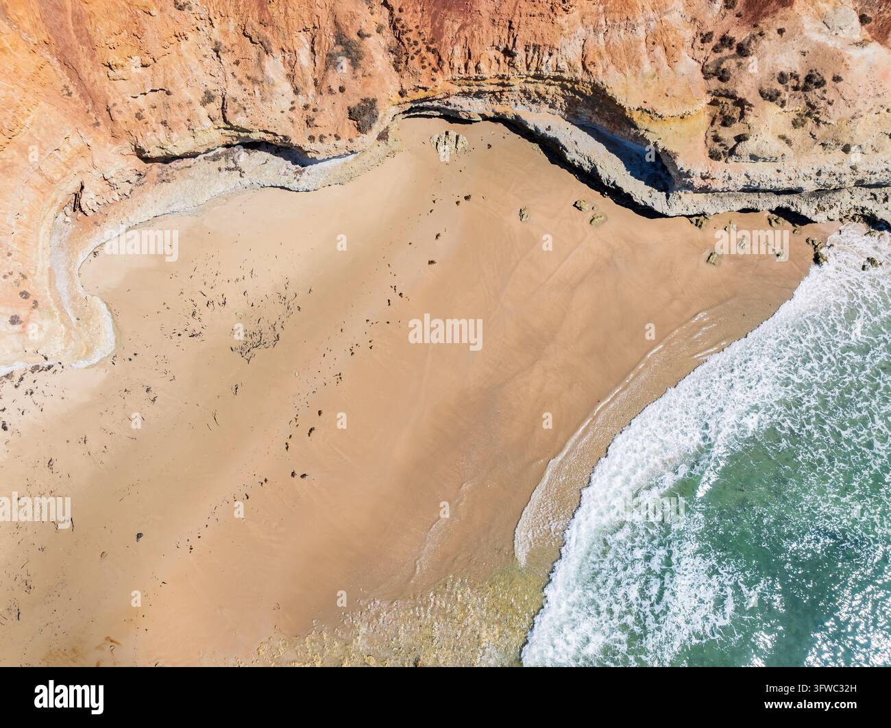 Vue aérienne des vagues roulant dans une petite baie en contrebas de falaises abruptes à Port Noarlunga à Adélaïde, en Australie du Sud. Banque D'Images