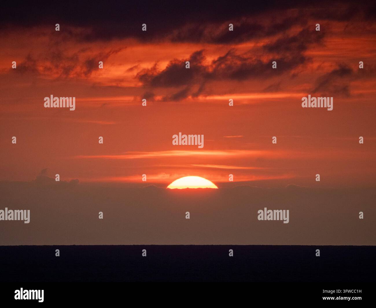 Couchant doré orange sur l'océan Atlantique avec des nuages épars, vu depuis une ferry traversant entre l'Espagne et Plymouth. Banque D'Images