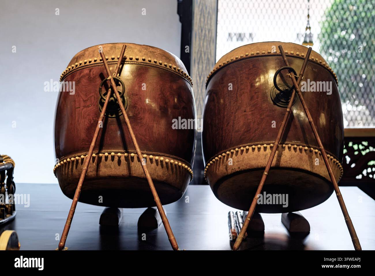 Deux tambours en bois authentiques fabriqués à la main avec des membranes en cuir, exposés à l'intérieur pour une performance musicale traditionnelle thaïlandaise et un fond culturel Banque D'Images