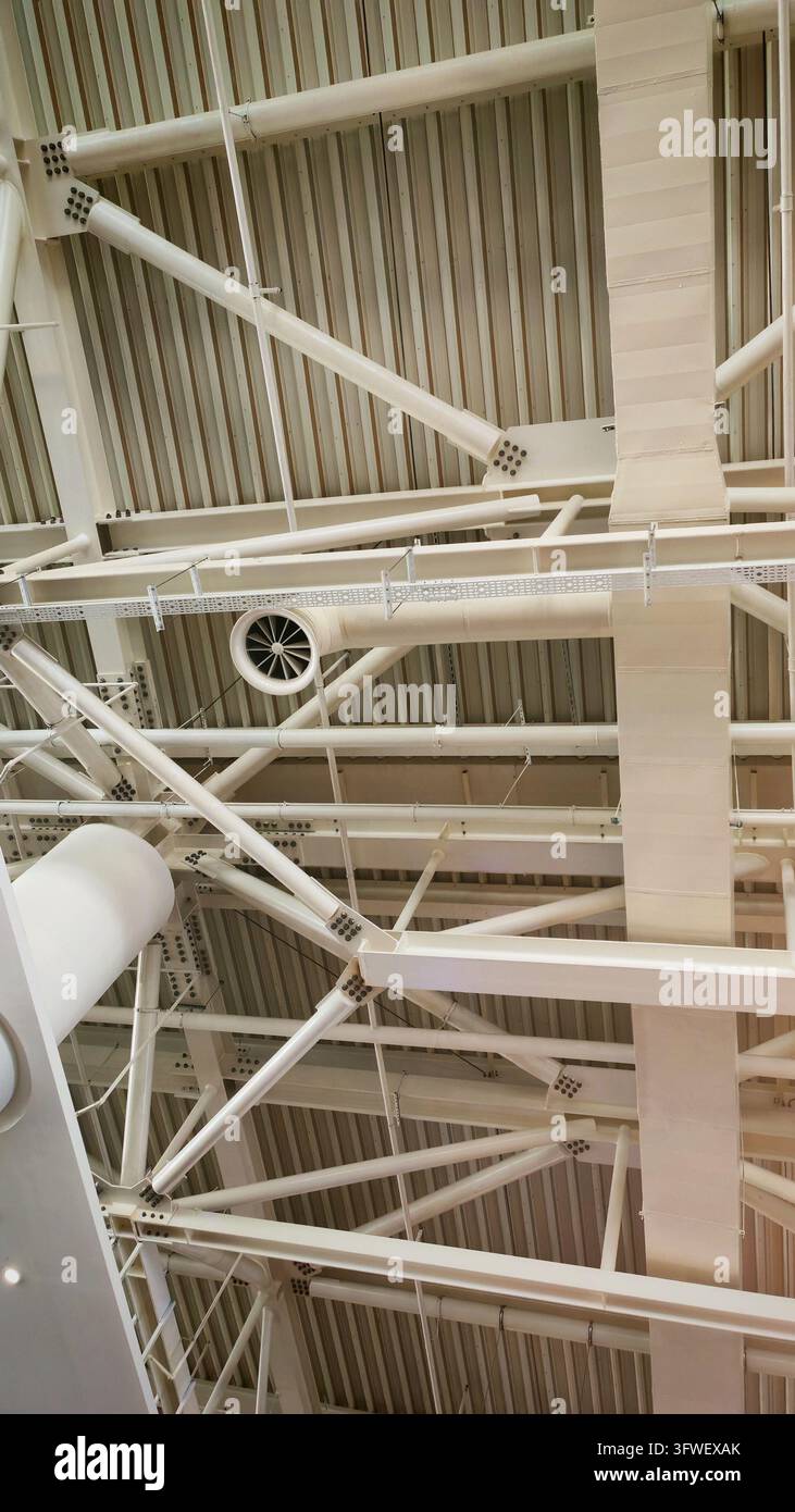 Poutres de plafond exposées, conduits et lumières suspendues Banque D'Images