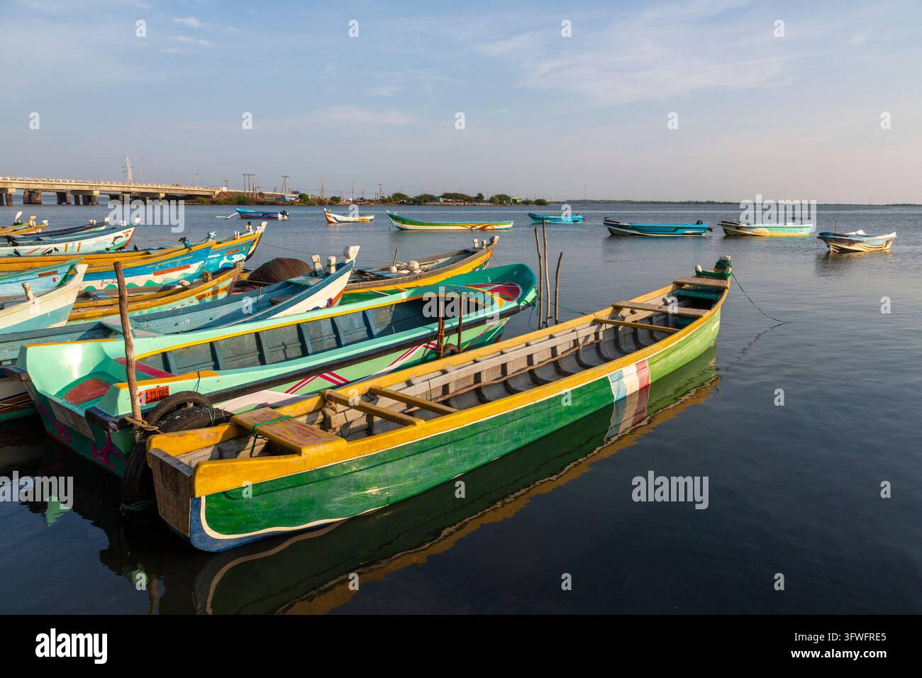 Bateaux de pêche en bois colorés amarrés dans des eaux calmes près d'un long pont, Province du Nord, Mannar, Sri Lanka Banque D'Images