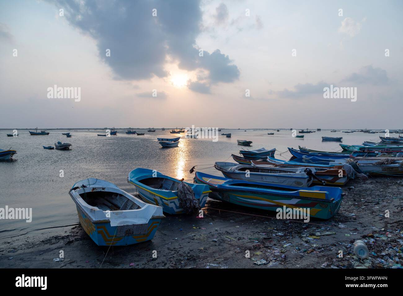 Bateaux de pêche colorés échoués sur une rive boueuse au coucher du soleil, Province du Nord, Jaffna, Sri Lanka Banque D'Images