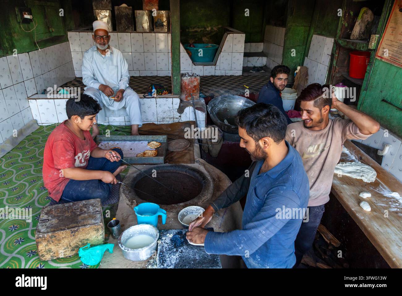 Boulangers préparant du pain traditionnel autour d'un four en argile tandoor, Jammu-et-Cachemire, Srinagar, Inde Banque D'Images