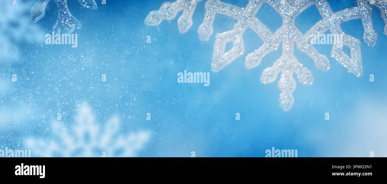 Décorations de flocons de neige scintillants sur un fond d'hiver bleu Banque D'Images