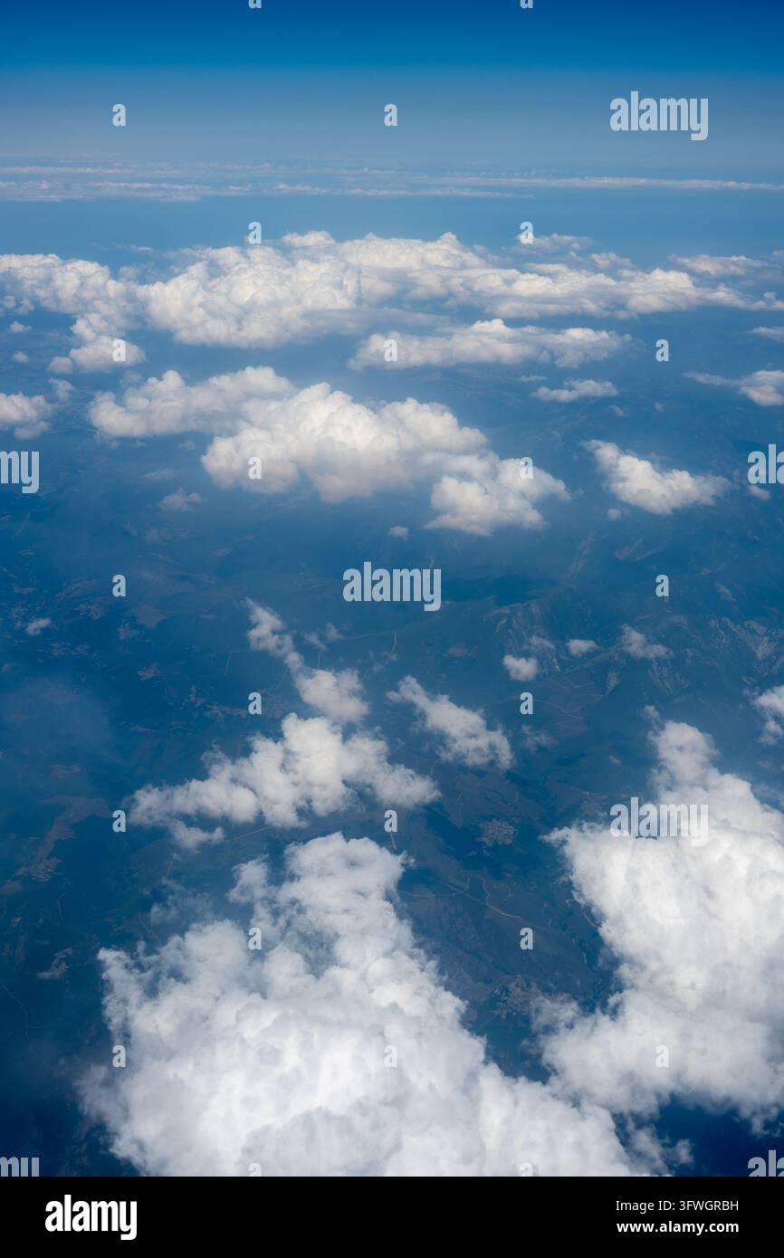 Des nuages cumulus blancs flottent au-dessus de montagnes et de vallées accidentées, photographiés depuis un avion volant entre Saint-Jacques-de-Compostelle et Barcelone, Spai Banque D'Images