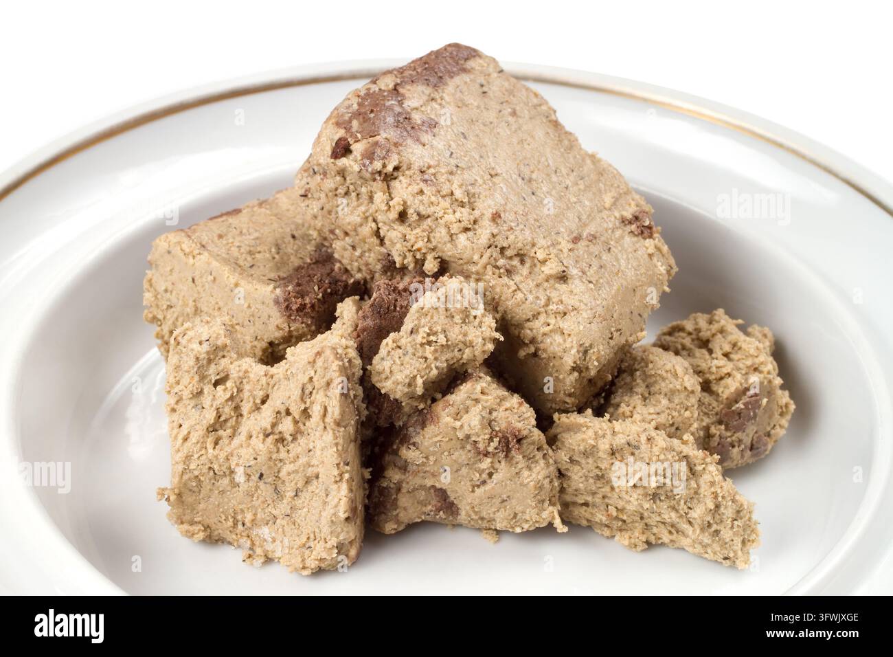 Halva sucrée dans une assiette. Confectionnerie en gros plan sur fond blanc. Banque D'Images