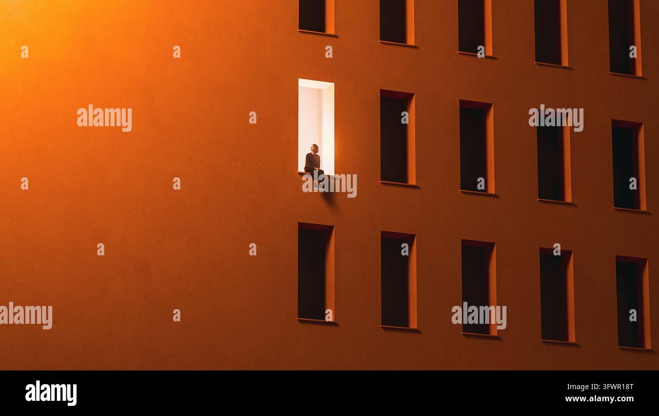 Une petite femme est assise sur le rebord de la seule fenêtre éclairée au milieu des ouvertures sombres d'une large façade orange. Banque D'Images