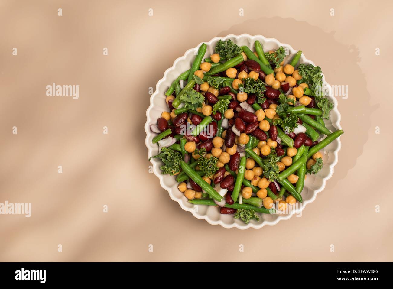 Salade fraîche de haricots mélangés et pois chiches avec sel rose de l'Himalaya sur fond beige. Concept de plats végétariens riches en protéines végétales. Nourriture saine. Copier l'espace Banque D'Images