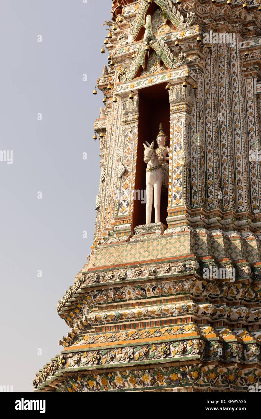 Bangkok, Thaïlande - 1er février 2026 : Une vue détaillée d'une tour de temple décorée présentant des motifs en mosaïque complexes et une statue blanche à l'intérieur d'un… Banque D'Images