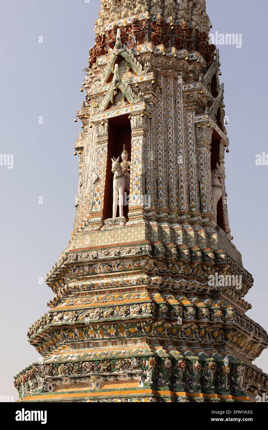 Bangkok, Thaïlande - 1er février 2026 : Une vue rapprochée d’une tour de temple très décorée présentant des motifs en mosaïque complexes et des statues à l’intérieur… Banque D'Images