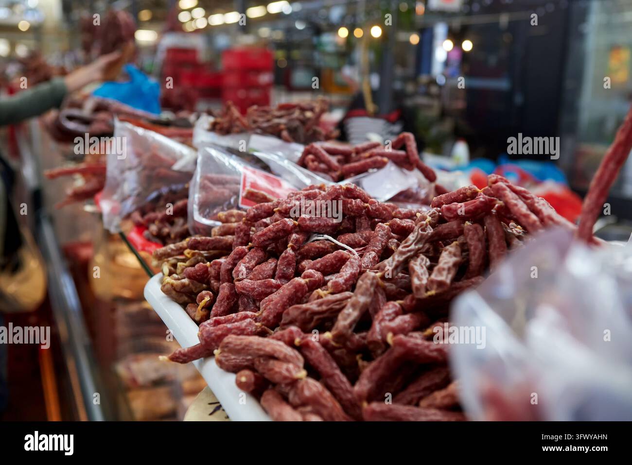 Saucisses séchées et produits carnés séchés exposés sur un étal de marché. Une variété de saucisses fumées et séchées à l'air est disposée pour la vente Banque D'Images