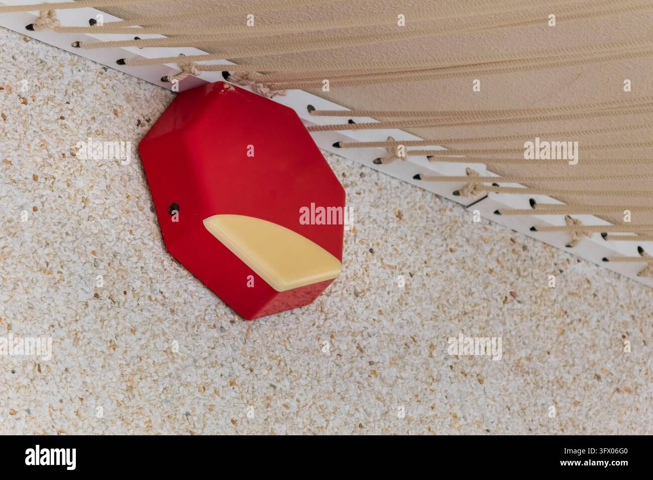 Sirène d'alarme rouge installée sur un mur texturé dans le cadre d'un système de sécurité et de sûreté du bâtiment. Banque D'Images