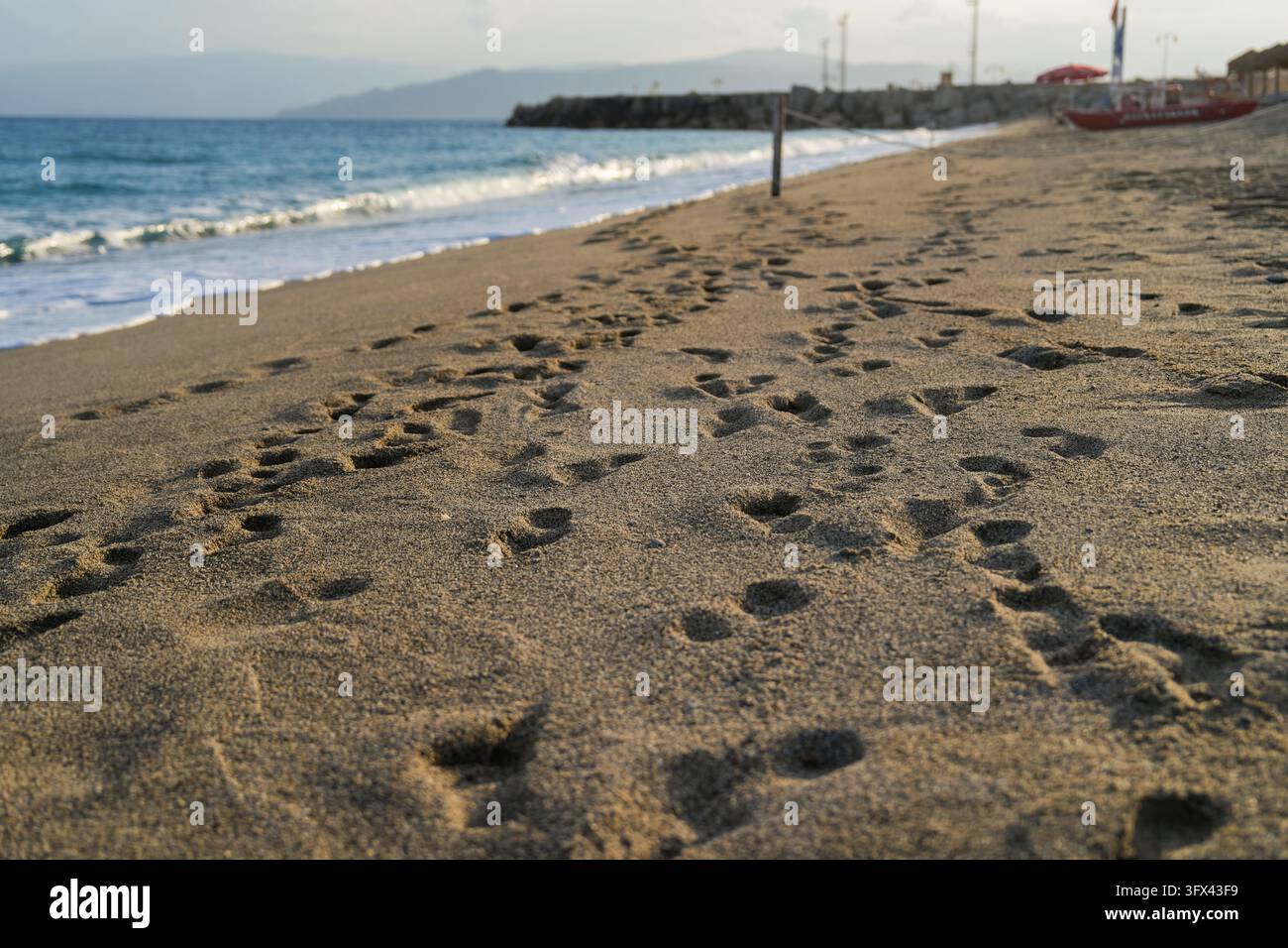 Empreintes de pas dans le sable sur une plage déserte au bord de la mer, Calabre, Italie Banque D'Images