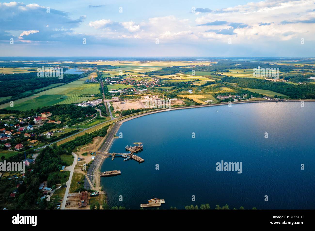 Vue aérienne de dessus de beau paysage avec grand lac dans la zone de campagne près de la petite ville le jour d'été. Lac Mietkow près de Wroclaw, Pologne Banque D'Images