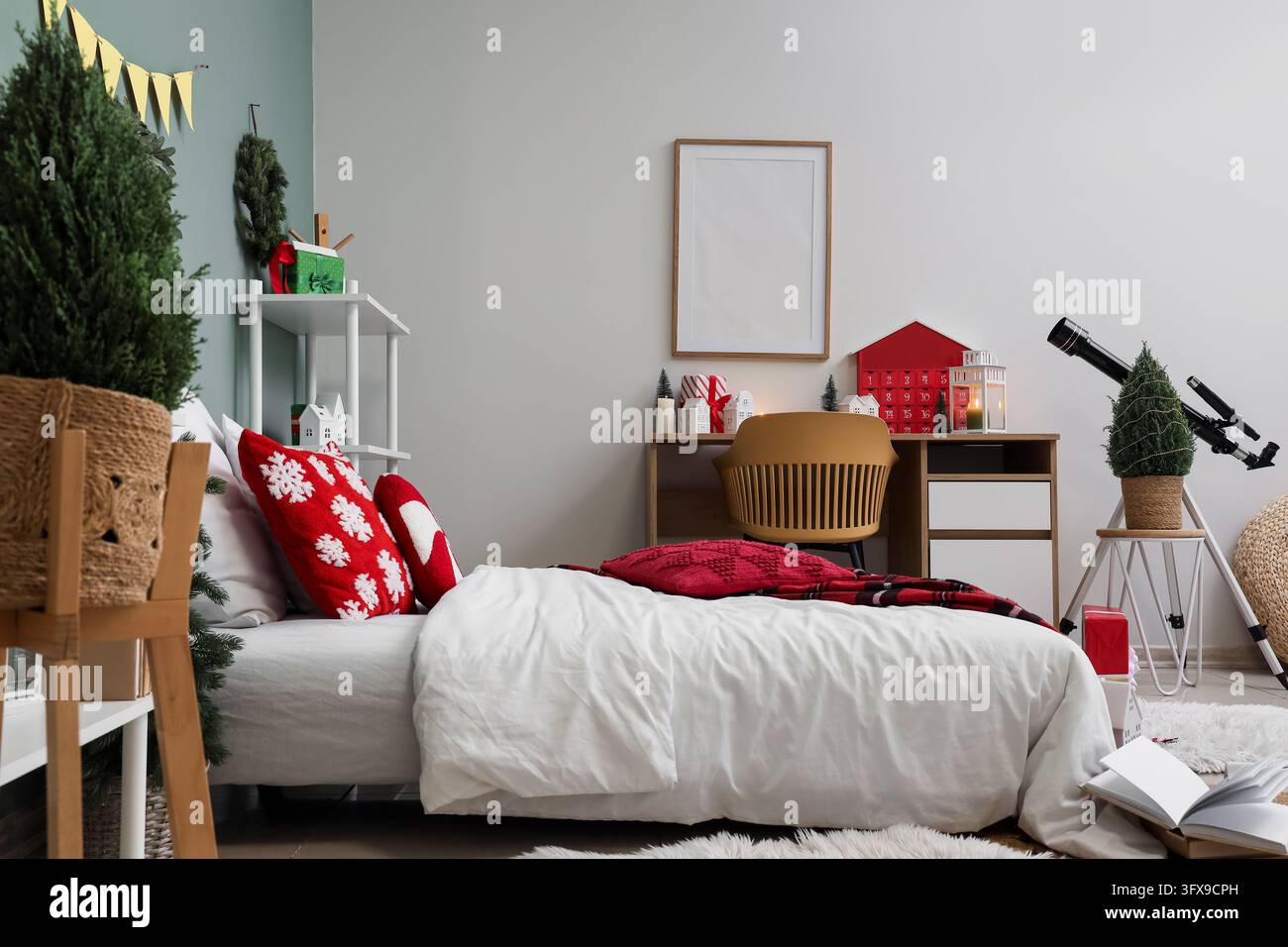 Intérieur de maison de Noël, chambre confortable décorée pour les fêtes hivernales avec une parure de lit festive, un calendrier de l'Avent et un télescope pour l'observation des étoiles dans la chambre Banque D'Images