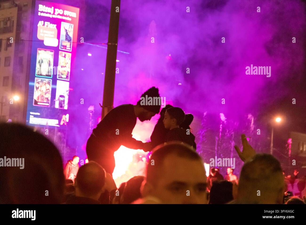 Une réunion festive sur la place Slavija à Belgrade, en Serbie, pendant la nuit des élections, avec une foule de personnes célébrant et célébrant la victoire annoncée Banque D'Images