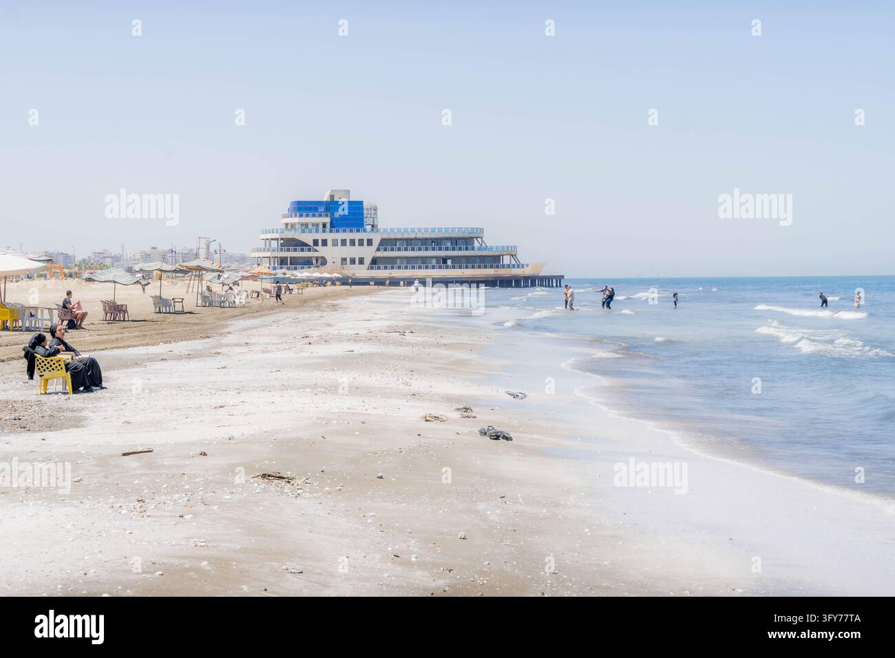 Côte méditerranéenne sablonneuse bordée de parasols dans la ville portuaire de Port-Saïd, en Égypte. Banque D'Images