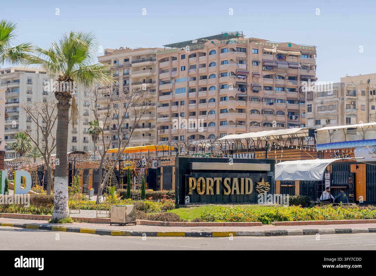 Le panneau de la ville de Port-Saïd décore une place paysagée du centre-ville devant des immeubles d'appartements à plusieurs étages dans le port méditerranéen de Port-Saïd, en Égypte. Banque D'Images